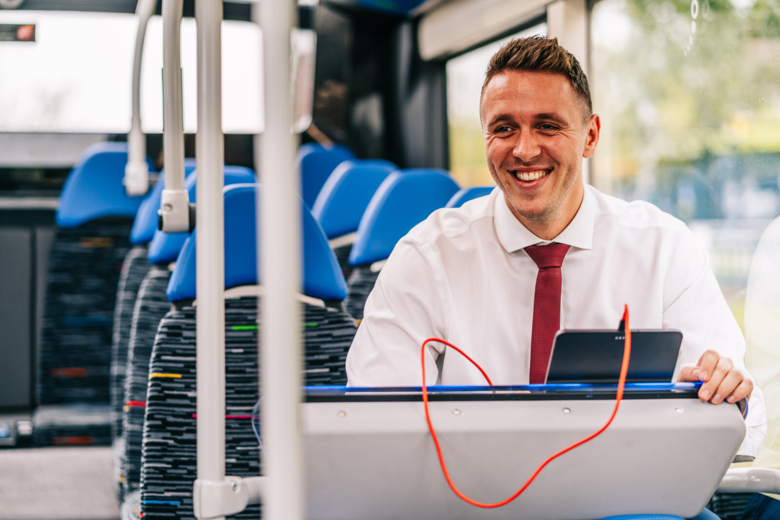 smart man in shirt and tie on a bus using an ipad charging dock