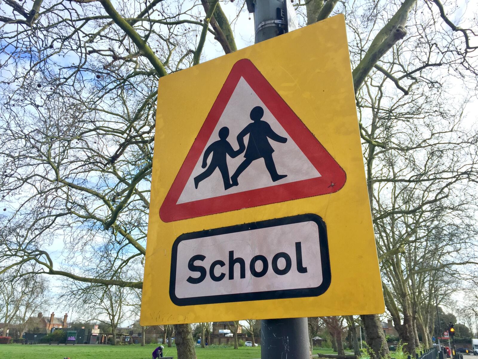 UK School crossing sign- red triangle with two children in it on a yellow background